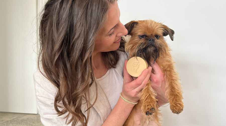 Dr Nicole Rous holding a Brussels Griffon dog with a shampoo bar. 